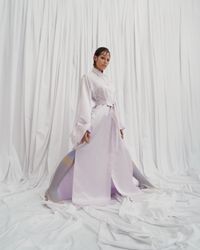 A daring pearl white gown with an androgynous air and bold bow sleeves, designed for the avant-garde bride. A sustainable wedding collection designed in Vienna, that redefines modern bridal fashion with its striking, minimalist aesthetic.