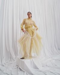 A daring pastel yellow tulle gown with sheer, flowing layers and bold ruffle accents, designed for the avant-garde bride. A sustainable wedding collection designed in Vienna, that redefines modern bridal fashion with its striking, minimalist aesthetic.