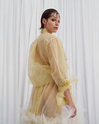 A daring pastel yellow tulle gown with sheer, flowing layers and bold ruffle accents, designed for the avant-garde bride. A sustainable wedding collection designed in Vienna, that redefines modern bridal fashion with its striking, minimalist aesthetic.