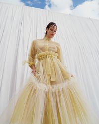 A daring pastel yellow tulle gown with sheer, flowing layers and bold ruffle accents, designed for the avant-garde bride. A sustainable wedding collection designed in Vienna, that redefines modern bridal fashion with its striking, minimalist aesthetic.