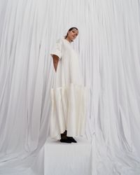 An avant-garde pearl white gown with bold puffy ruffles and short, wide sleeves, designed for the unconventional bride. A sustainable wedding collection designed in Vienna, that redefines modern bridal fashion with its striking, minimalist aesthetic.