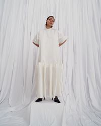 An avant-garde pearl white gown with bold puffy ruffles and short, wide sleeves, designed for the unconventional bride. A sustainable wedding collection designed in Vienna, that redefines modern bridal fashion with its striking, minimalist aesthetic.