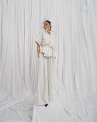 An elegant cream white combination with wide, long pants and subtle oniric accents, designed for the avant-garde bride. A sustainable wedding collection designed in Vienna, that redefines modern bridal fashion with its striking, minimalist aesthetic.