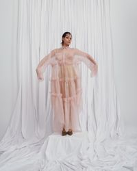 A daring pastel pink gown with sheer, flowing layers and bold ruffle accents, designed for the modern bride. A sustainable wedding collection designed in Vienna, that redefines modern bridal fashion with its striking, minimalist aesthetic.