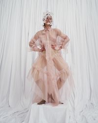 A daring pastel pink gown with sheer, flowing layers and bold ruffle accents, designed for the modern bride. A sustainable wedding collection designed in Vienna, that redefines modern bridal fashion with its striking, minimalist aesthetic.